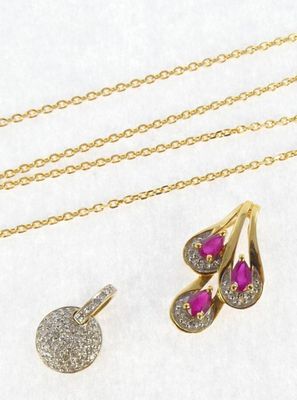two gold necklaces and a pair of ruby and diamond earrings