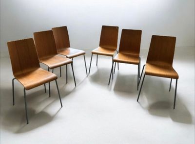 several chairs are arranged in a circle in a white room