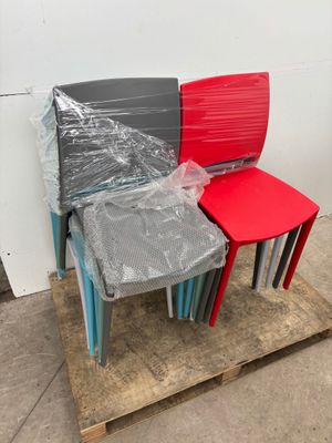several plastic chairs are stacked on a pallet in a warehouse