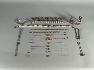 a lot of silver and gold jewelry on a white table
