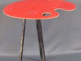 une table rouge sur laquelle se trouve une palette de peinture rouge