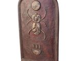 a metal plaque with a bug on it on a white background