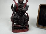 a statue of a man sitting on a chair next to a picture of a man