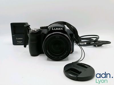 the camera is sitting next to a charger on the table