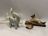 trois figurines d'animaux sont posées sur une surface blanche