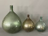 three glass vases sitting next to each other on a table