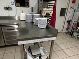 a kitchen with many plates and pans on the counter
