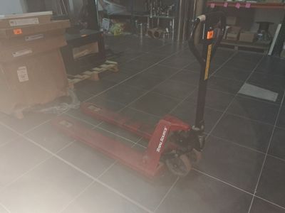a red fork lifter sitting on the floor in a room