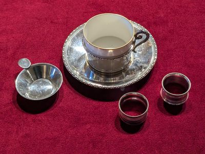 trois tasses et une soucoupe posées sur une nappe rouge