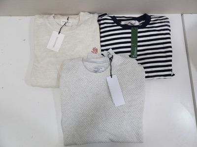three men ' s t - shirts in a box with tags on them