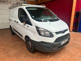 La camionnette blanche est garée dans le garage, devant un rideau rouge.
