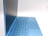 a laptop with a blue keyboard sitting on a white surface
