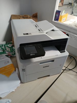 une imprimante posée sur un bureau près d'une fenêtre