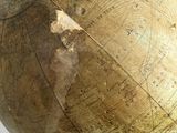 an old globe that is on a stand on a table