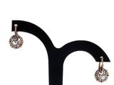 a close up of a pair of earrings on a stand