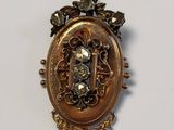 a gold pendant with a picture of a person on it
