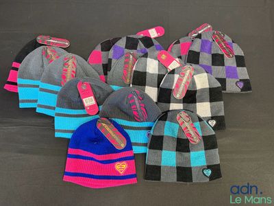 several hats are lined up on a table with tags on them