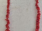 un collier en corail rouge avec un fermoir en argent sur fond blanc