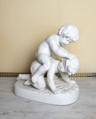a statue of a boy and a girl on a marble base
