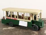 un petit bus en jouet posé par terre