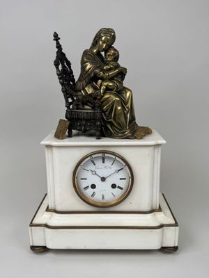 une statue représentant une femme assise sur un banc, avec une horloge