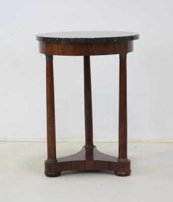 an image of a small round table with a wooden base