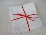 a white napkin with a red ribbon wrapped around it