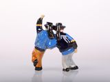two figurines of two men wrestling each other
