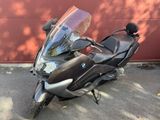 moto garée devant un immeuble, avec un mur rouge en arrière-plan
