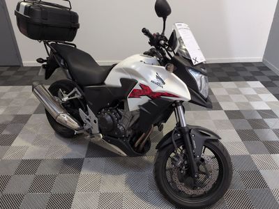 une moto blanche et noire garée sur un sol à damier