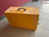 a yellow suitcase sitting on the floor next to a red wall