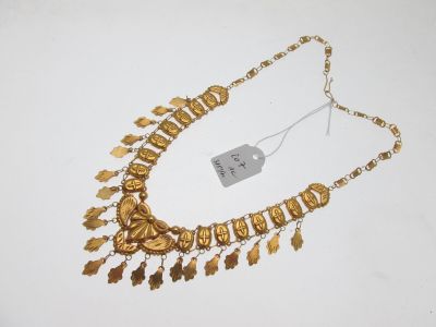 gros plan d'un collier en or sur une surface blanche