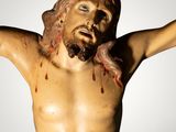 a statue of jesus on the cross with blood all over it