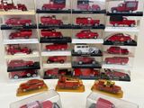 many different types of toy fire trucks displayed in a display case