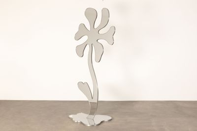 a metal sculpture of a flower on a stand