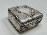a silver box with a heart on it on a table