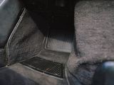 a car dashboard with a black carpet and a gray floor mat