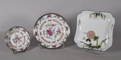 three pieces of china with flowers and leaves are displayed on a table