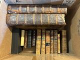 de nombreux vieux livres dans une boîte en carton posée par terre