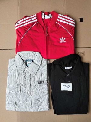 three adidas tracksuits and a t - shirt on a cardboard box