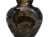 a glass vase with a face on it sitting on a table
