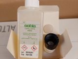 a bottle of liquid sitting on top of a cardboard box