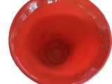 a red bowl that is sitting on a white surface