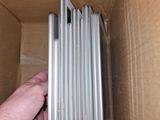 a hand that is opening a box that has a bunch of laptops in it
