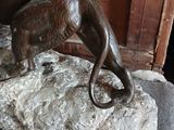 a statue of a cat on a rock on a chair