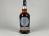 une bouteille de whisky posée sur une surface blanche