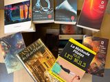 several books are sitting on top of a cardboard box on a table