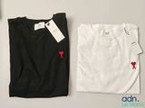 two white and black shirts with red hearts on them on a table