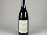 une bouteille de vin vide posée sur une table blanche