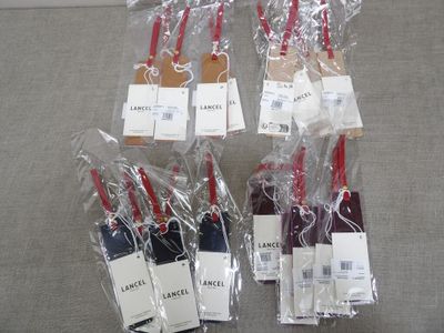 six pieces of luggage are wrapped in plastic bags on a couch
